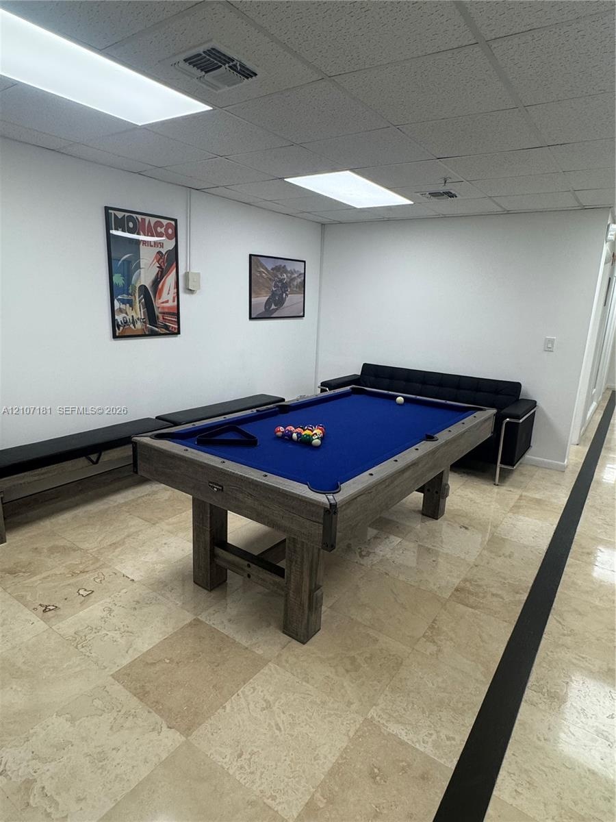 Large-format stone tile flooring and recessed panel ceiling lighting