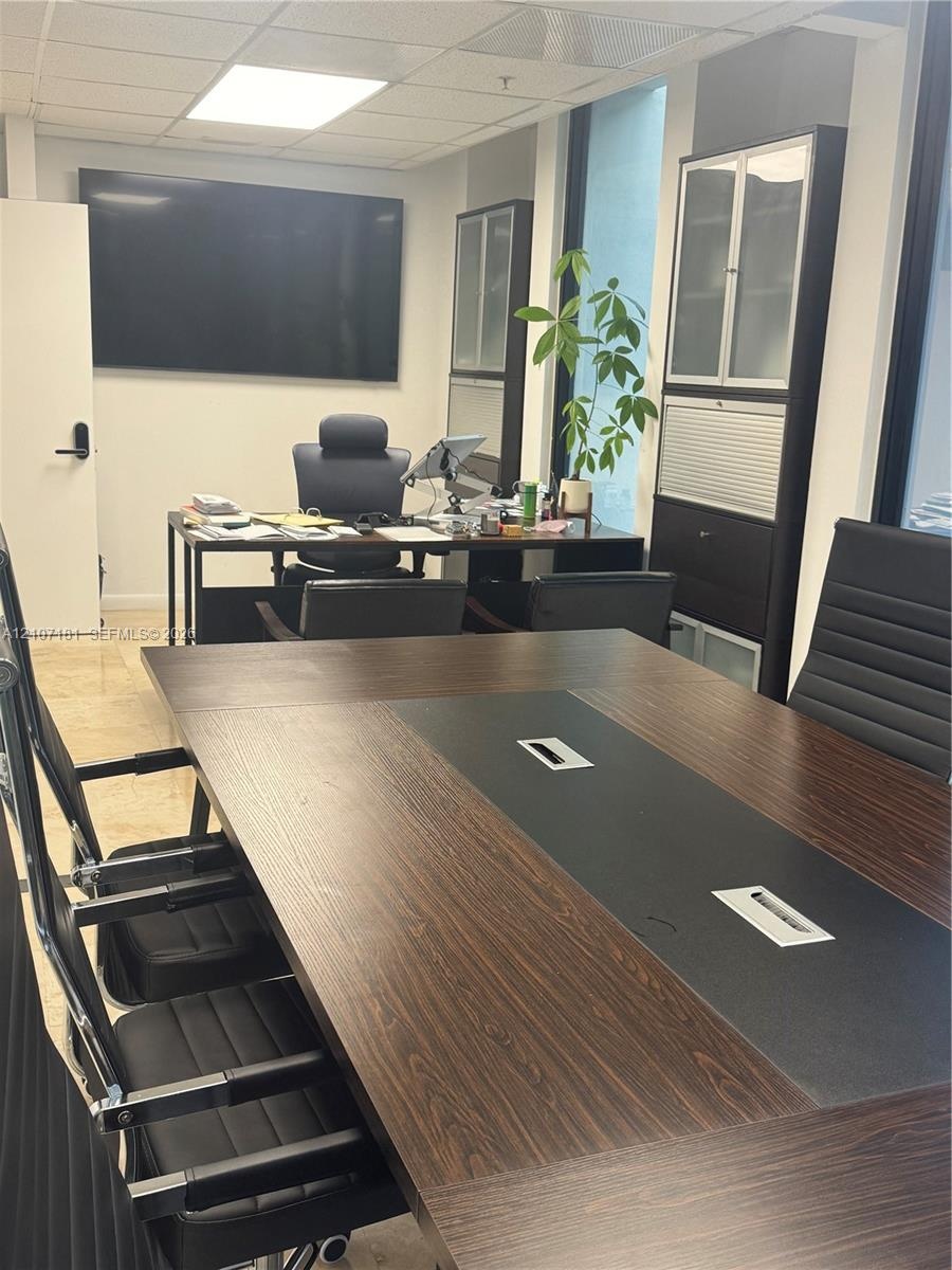 Built-in dark-toned cabinetry, integrated cable management desk systems, recessed lighting, and tile flooring