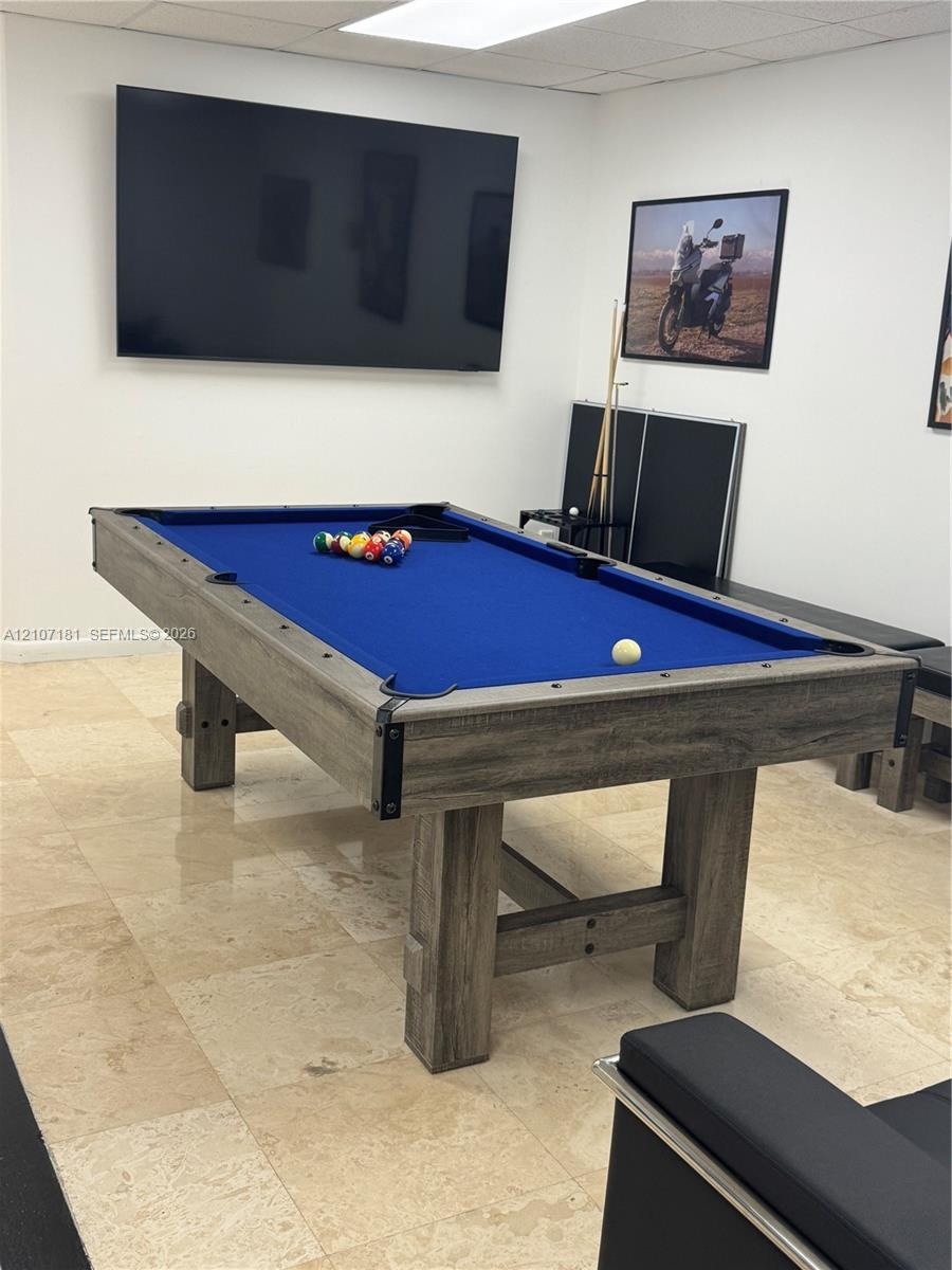 Interior space featuring light-toned stone-finish tile flooring and recessed ceiling lighting