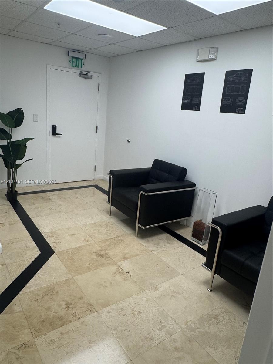 Interior space featuring stone tile flooring with decorative dark inlays, recessed ceiling lighting, and a neutral color palette