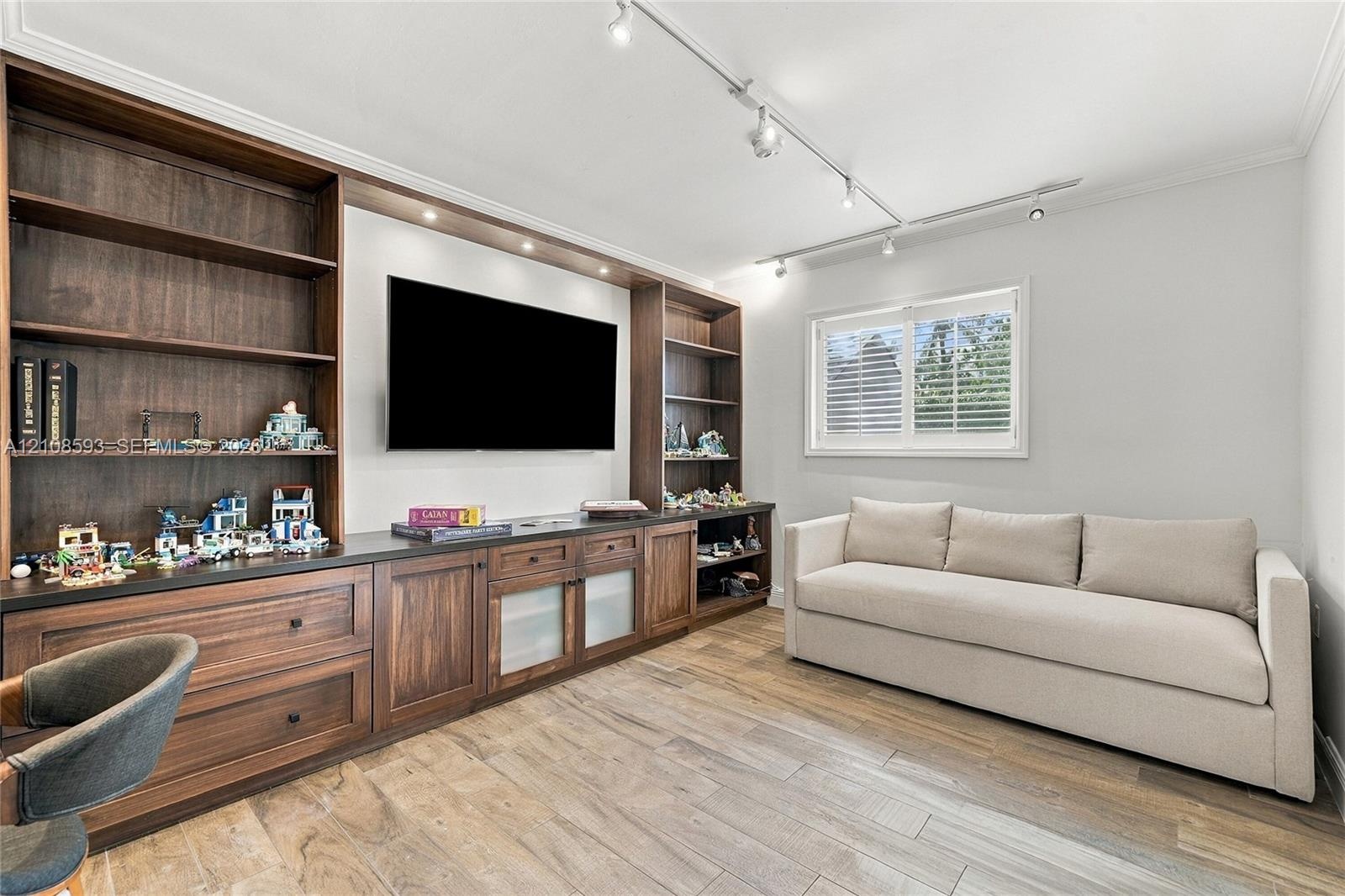 Built-in wall-to-wall cabinetry featuring dark wood finish, open shelving, lower storage drawers, and recessed lighting, finished with wood-finish flo