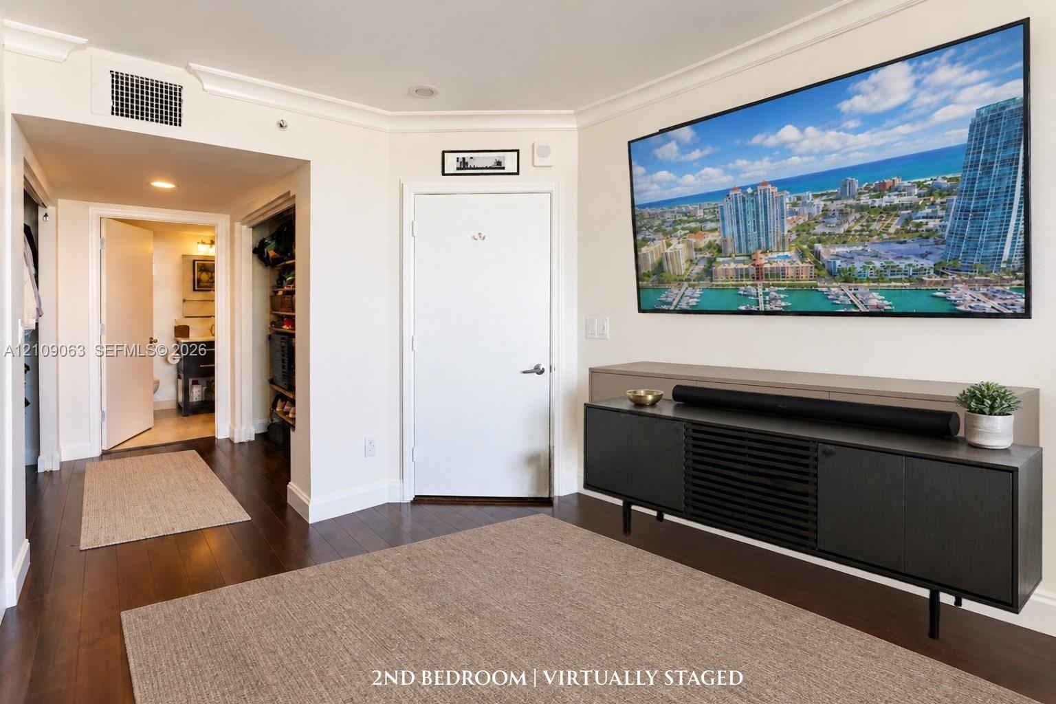 Interior space featuring dark wood-finish flooring, crown molding, and recessed lighting