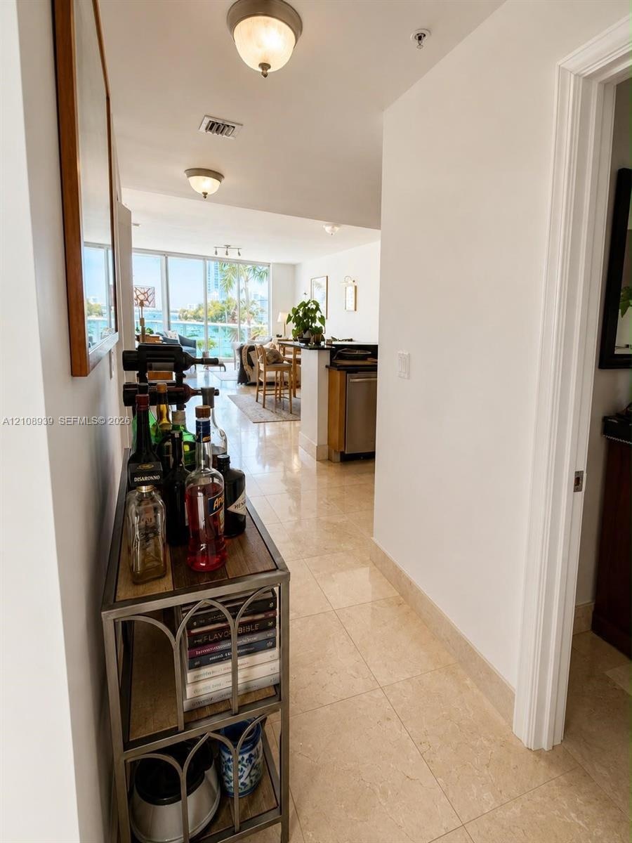 Large-format polished tile flooring, flush-mount ceiling lighting, and floor-to-ceiling glass paneling