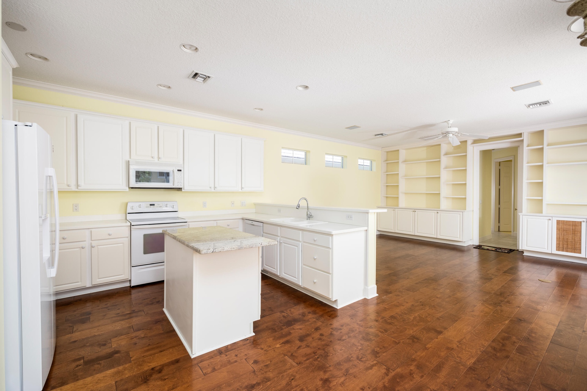 beautiful wood floors, white kitchen, island storage custom shelves