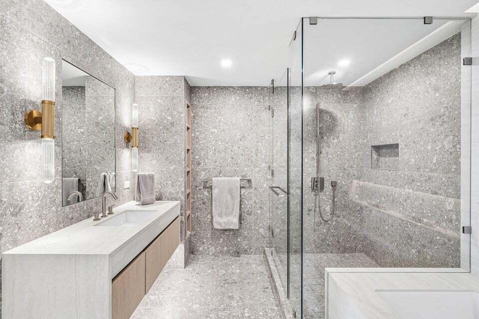 Indulge in a spa-inspired primary bathroom featuring an elegant double vanity, sophisticated finishes, and a spacious glass-enclosed shower for the ul