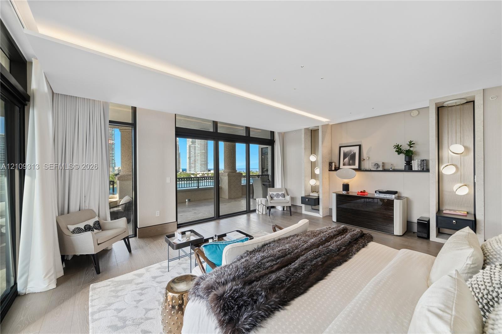 Floor-to-ceiling sliding glass doors, built-in recessed shelving with integrated accent lighting, light-toned wood-finish flooring, and a covered balc