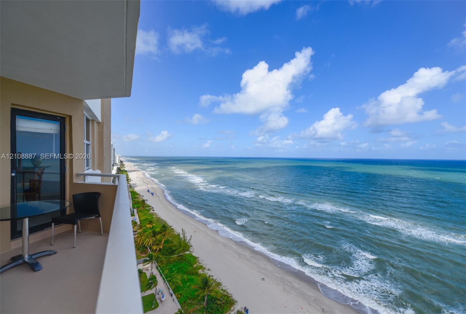 Covered balcony featuring metal railing and direct ocean exposure