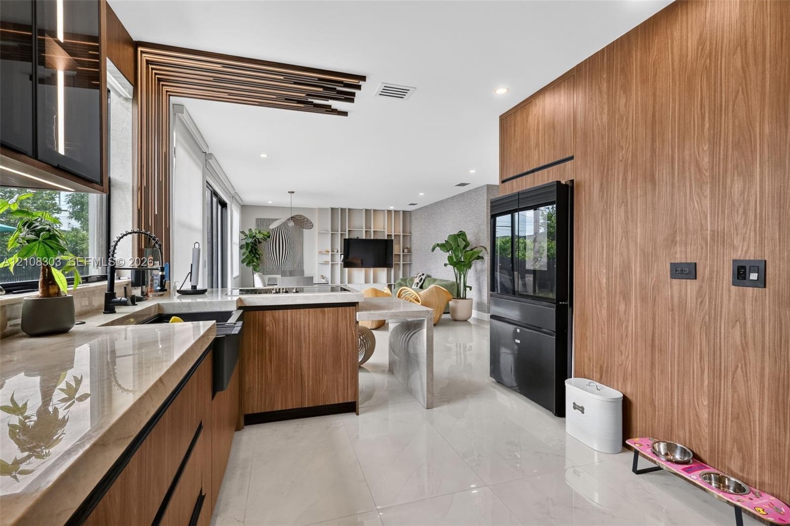 Kitchen featuring wood-finish cabinetry, stone countertops, a deep basin sink with a matte black faucet, integrated full-height cabinetry, and archite