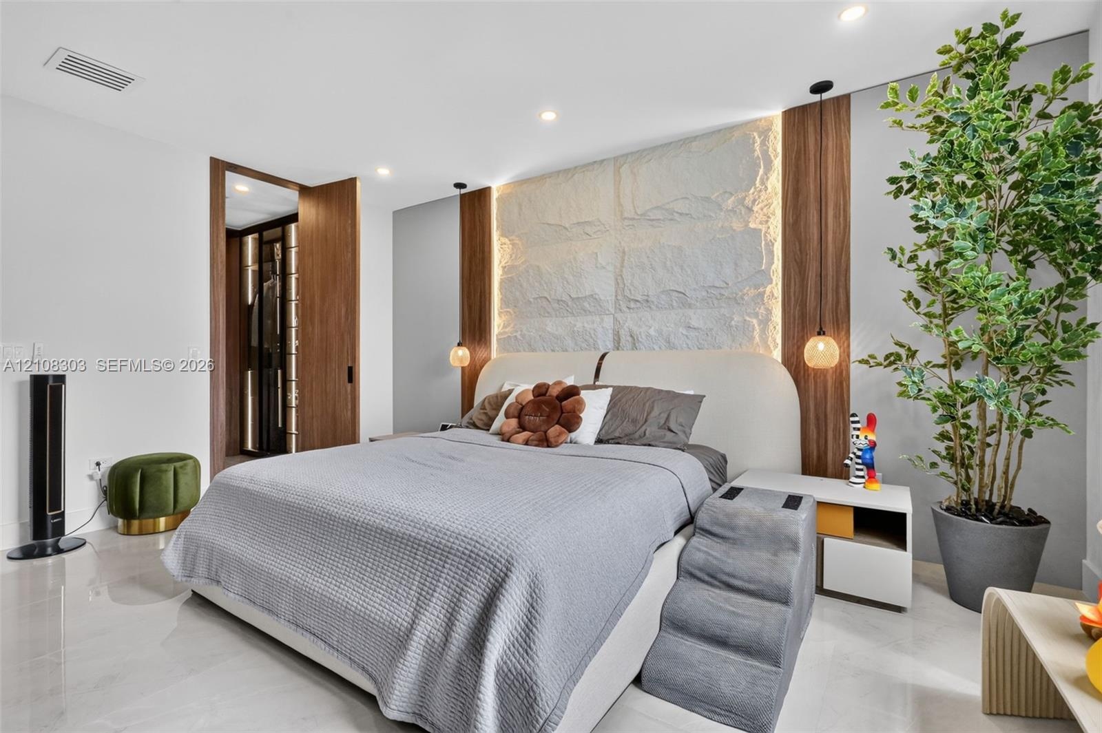 Textured stone accent wall with integrated perimeter lighting, floor-to-ceiling wood paneling, recessed ceiling lighting, and tile flooring