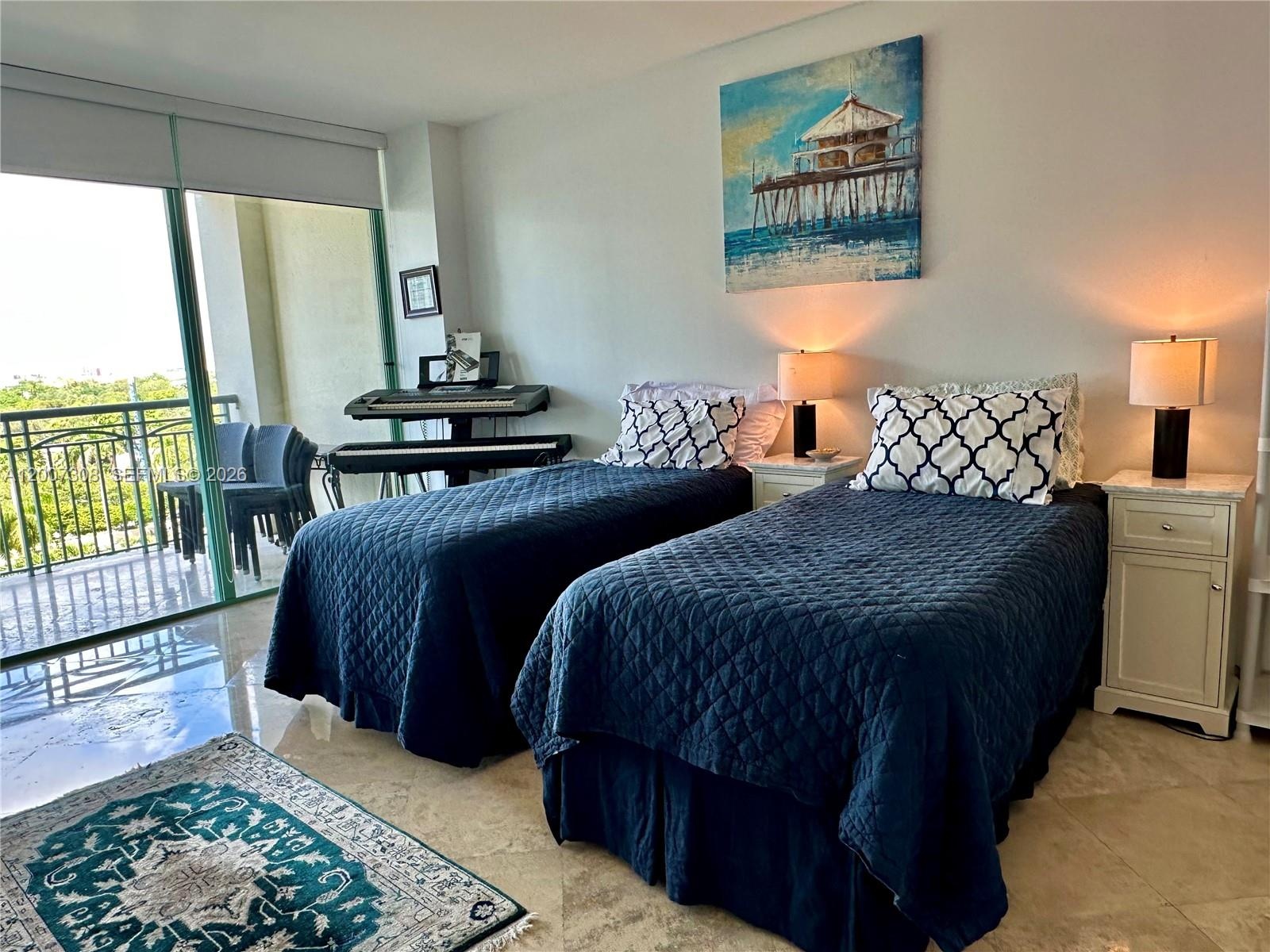 Polished stone flooring, floor-to-ceiling glass sliding doors, and a private balcony with metal railing