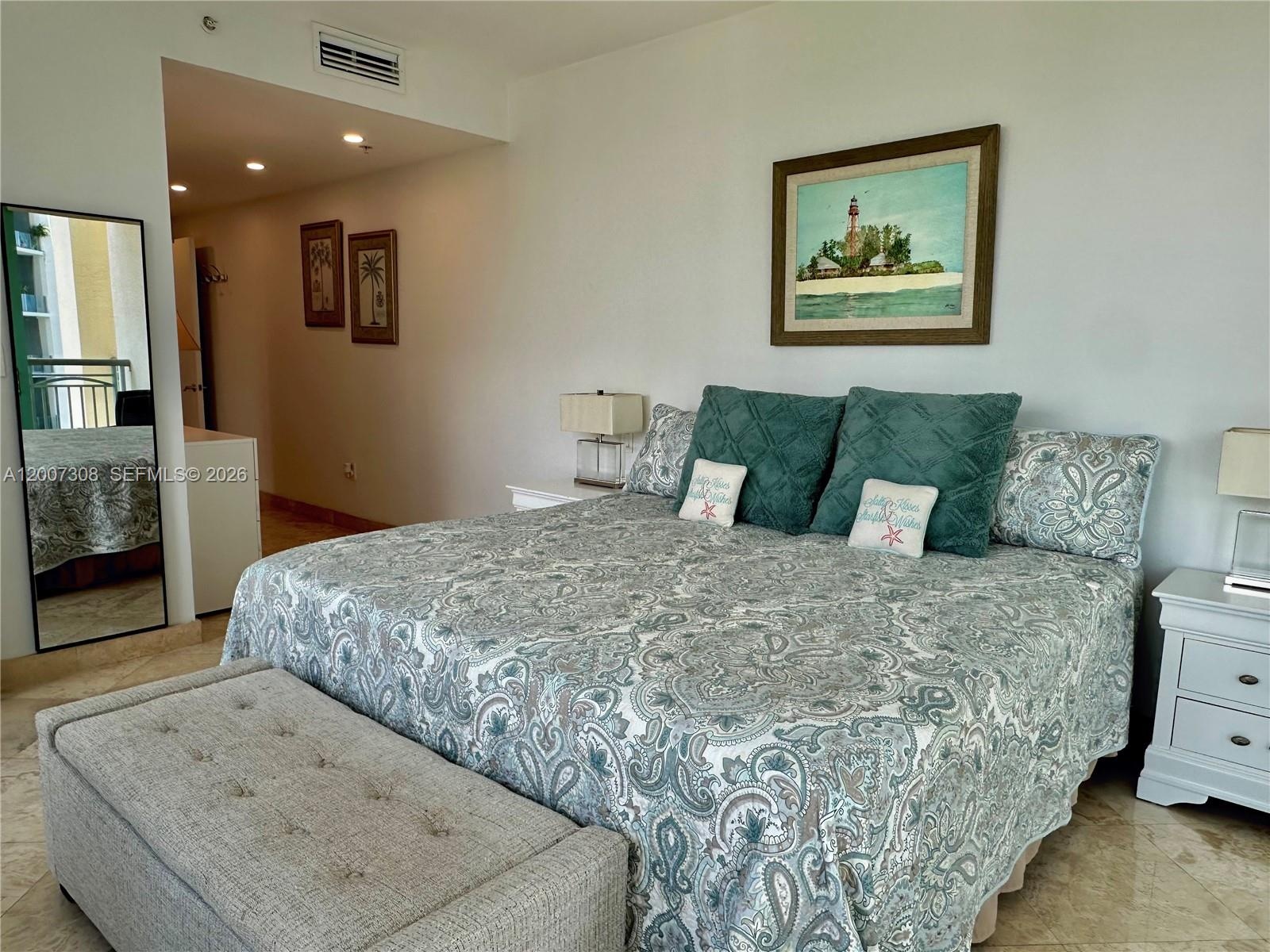 Stone-finish flooring throughout, recessed ceiling lighting, and a full-length floor mirror with a black frame
