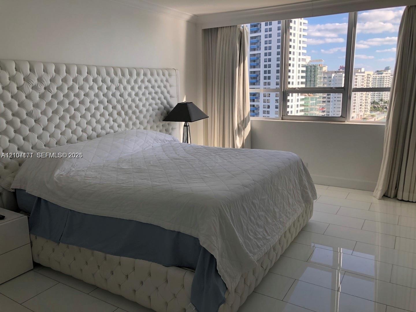 Large-format tile flooring, floor-to-ceiling windows, and urban cityscape backdrop