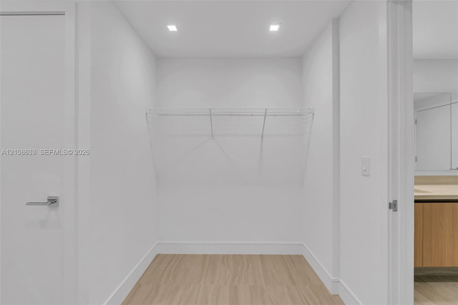 Closet featuring wood-finish flooring, integrated wire shelving, and recessed ceiling lighting