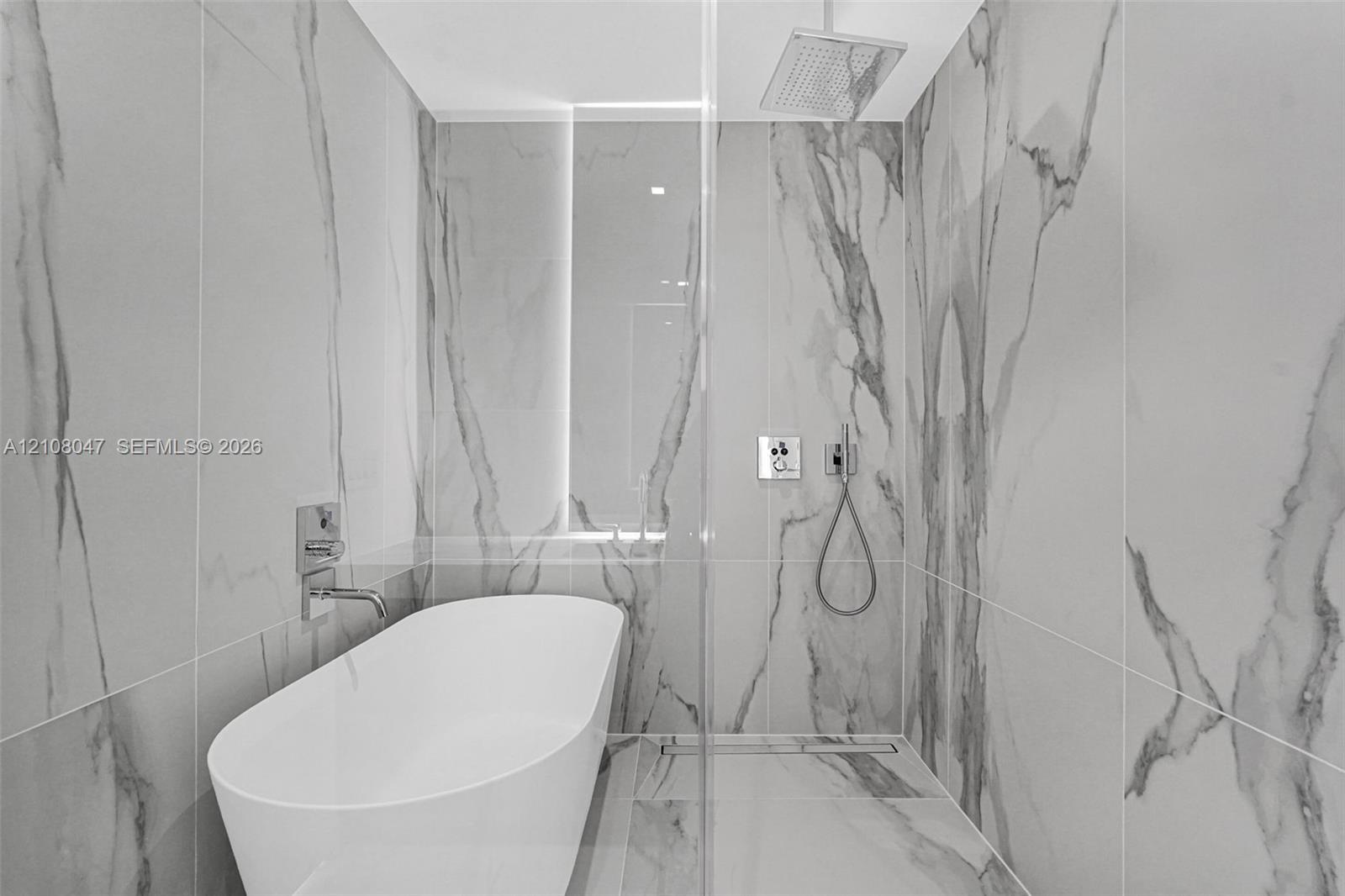 Freestanding soaking tub, walk-in shower, rain shower head, hand-held shower, and wall-mounted plumbing fixtures, all surrounded by large-format porce