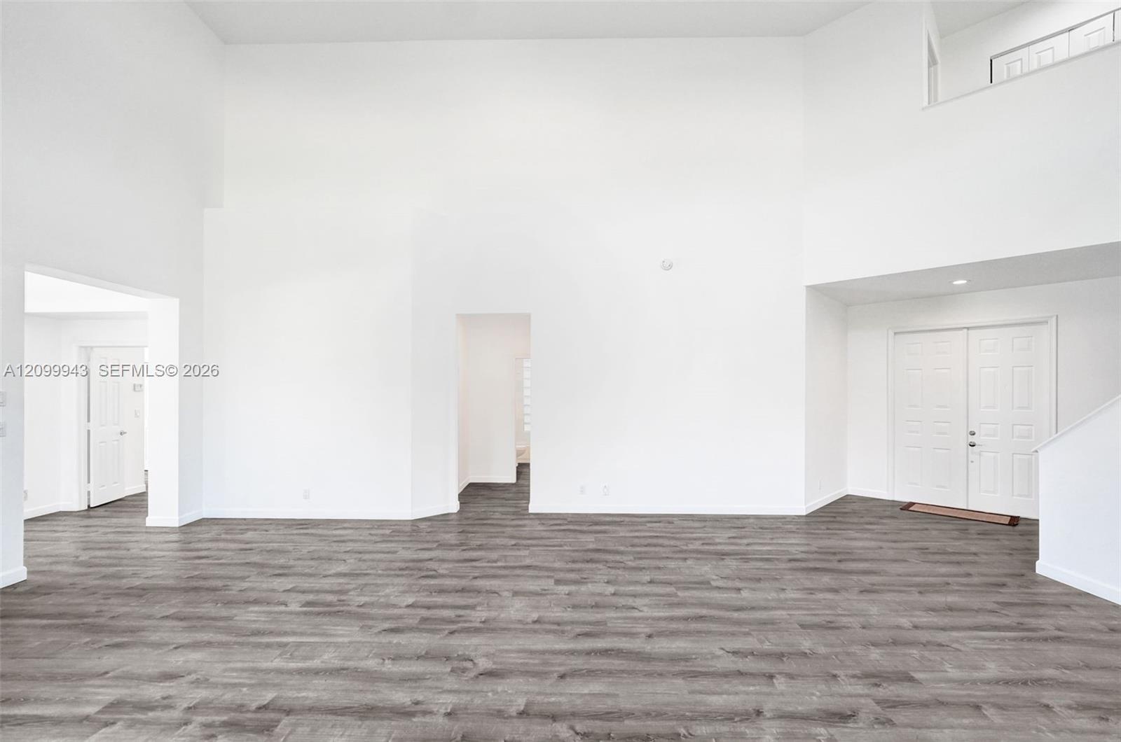 Vaulted ceilings, wood-finish flooring, double-door entryway, and recessed lighting