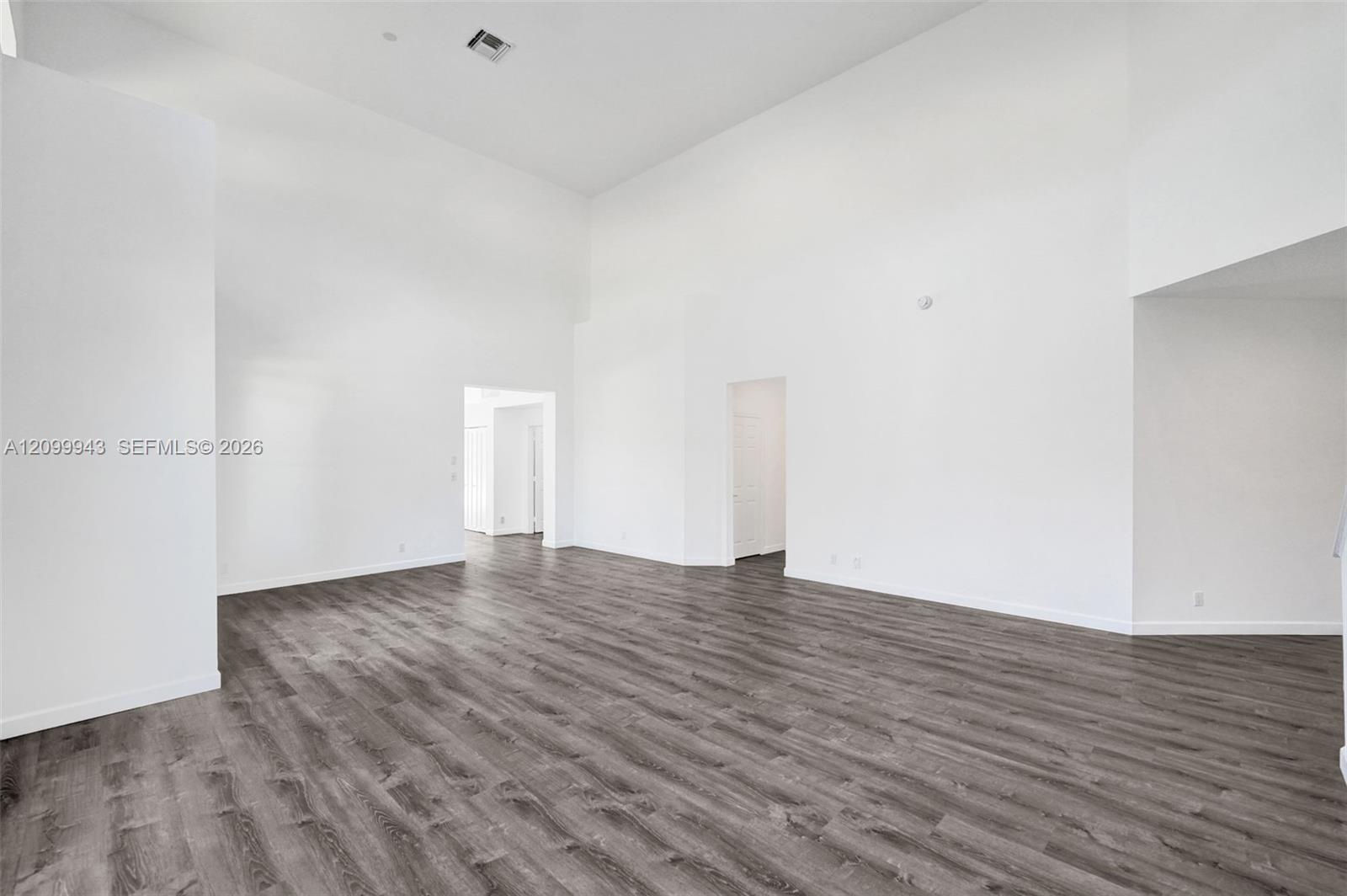 Vaulted ceilings, expansive open-concept interior, and dark wood-finish flooring