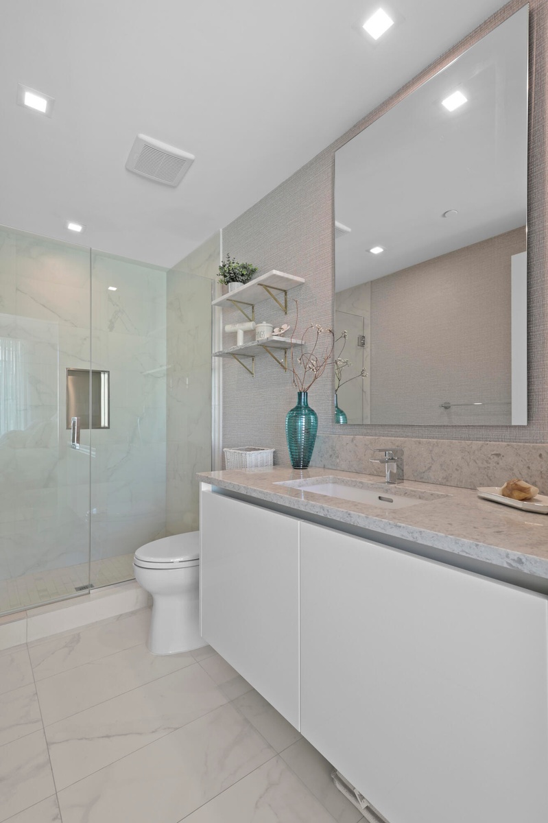 Guest bedroom 1 features more designer touches, automated shades & blinds, customized closet, and ensuite bathroom.