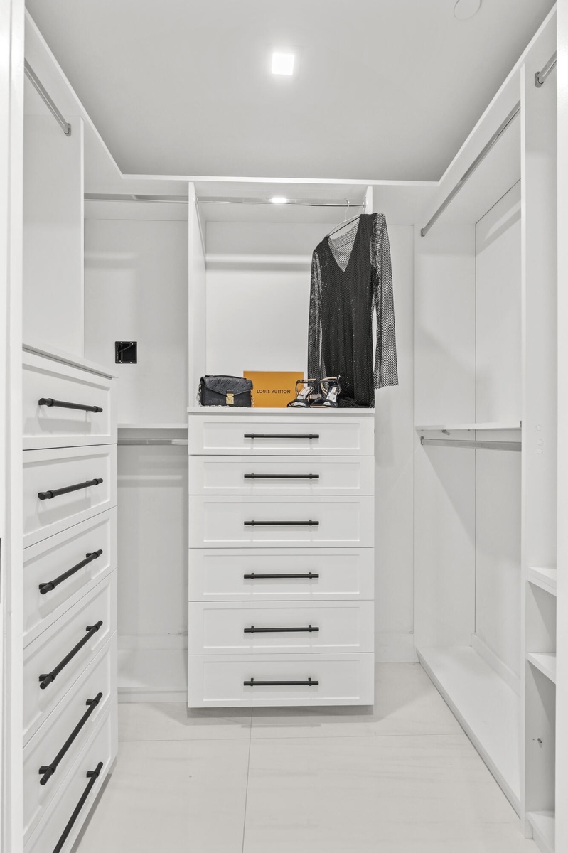 Fully customized cabinetry adorn the his & hers closets providing maximum storage and function.