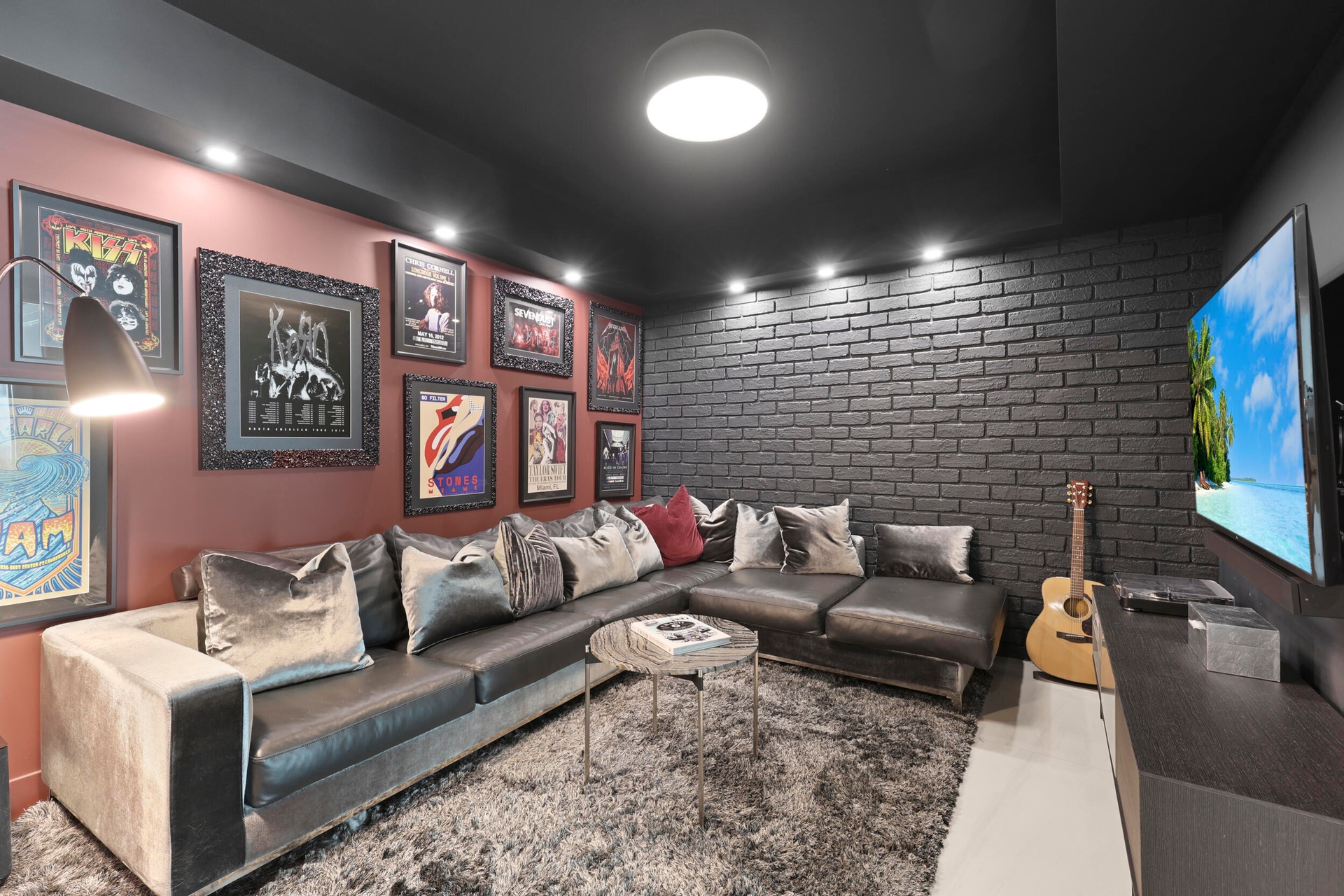 A true showstopper, the den brings bold character and unexpected warmth to this oceanfront residence. A custom faux brick accent wall and dramatic lig