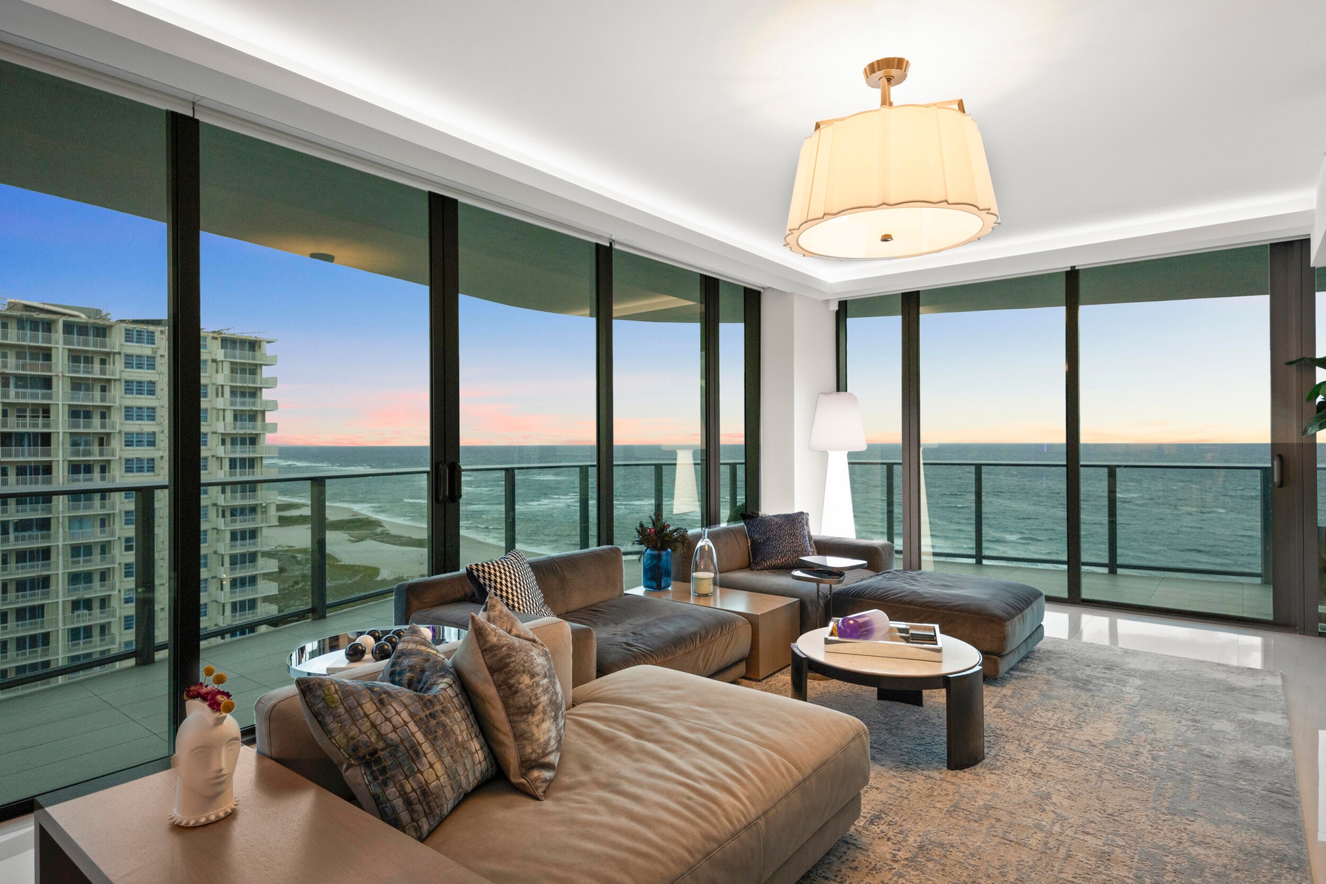 As the sun sets, custom lighting and illuminated accent walls glow in harmony with the soft, colorful evening light that fills the residence.
