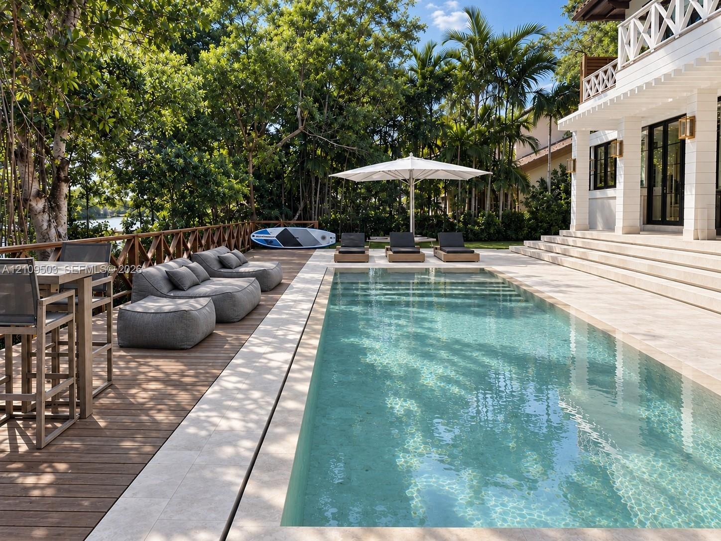Rectangular swimming pool with stone surround, wood-finish decking, and tiered patio steps leading to a white exterior structure