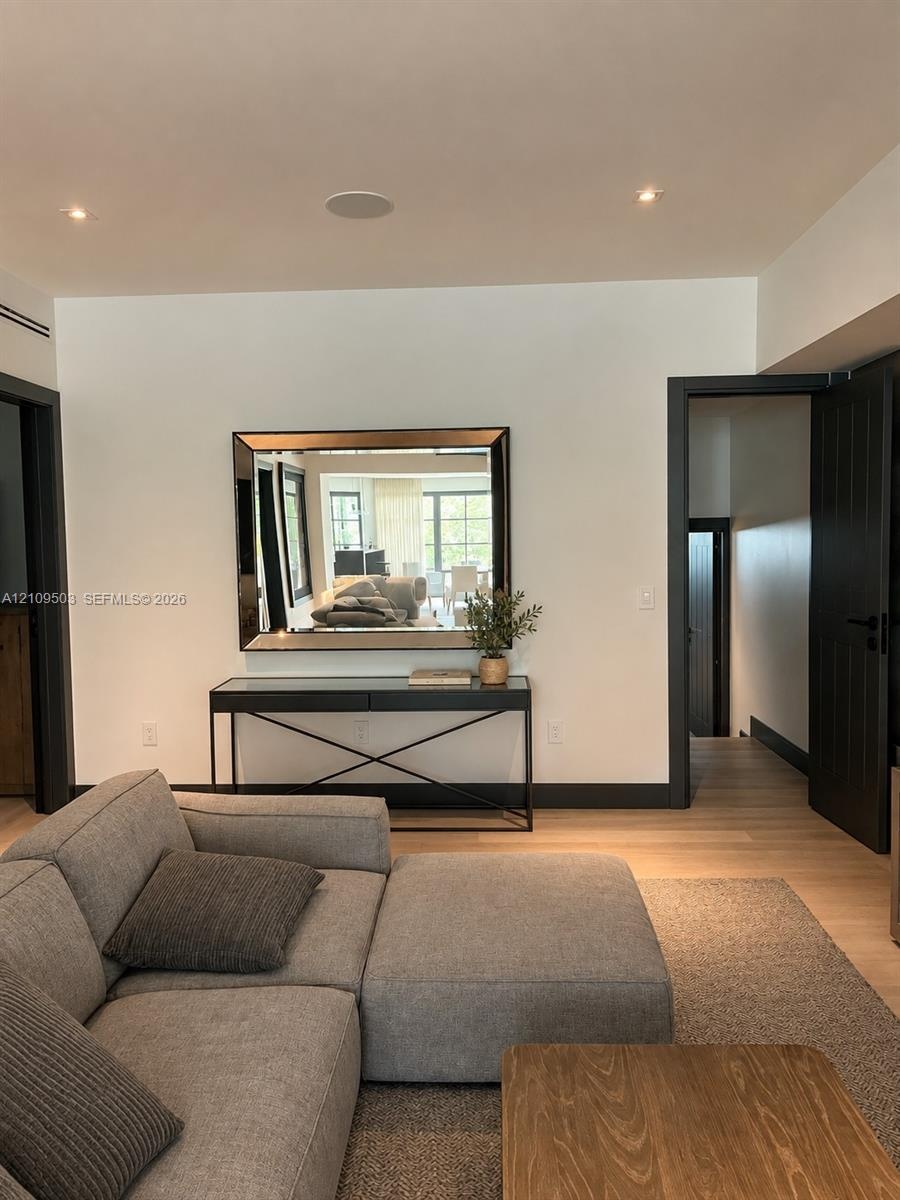 Interior space featuring wood-finish flooring, recessed lighting, and bold dark-toned door frames with matching paneled doors