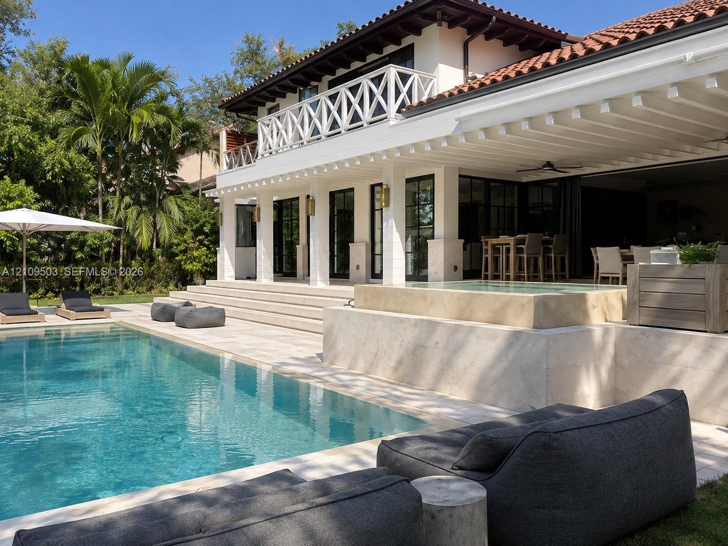 Exterior terrace featuring a swimming pool, integrated spa, covered patio with recessed lighting, and a second-level balcony with white lattice railin