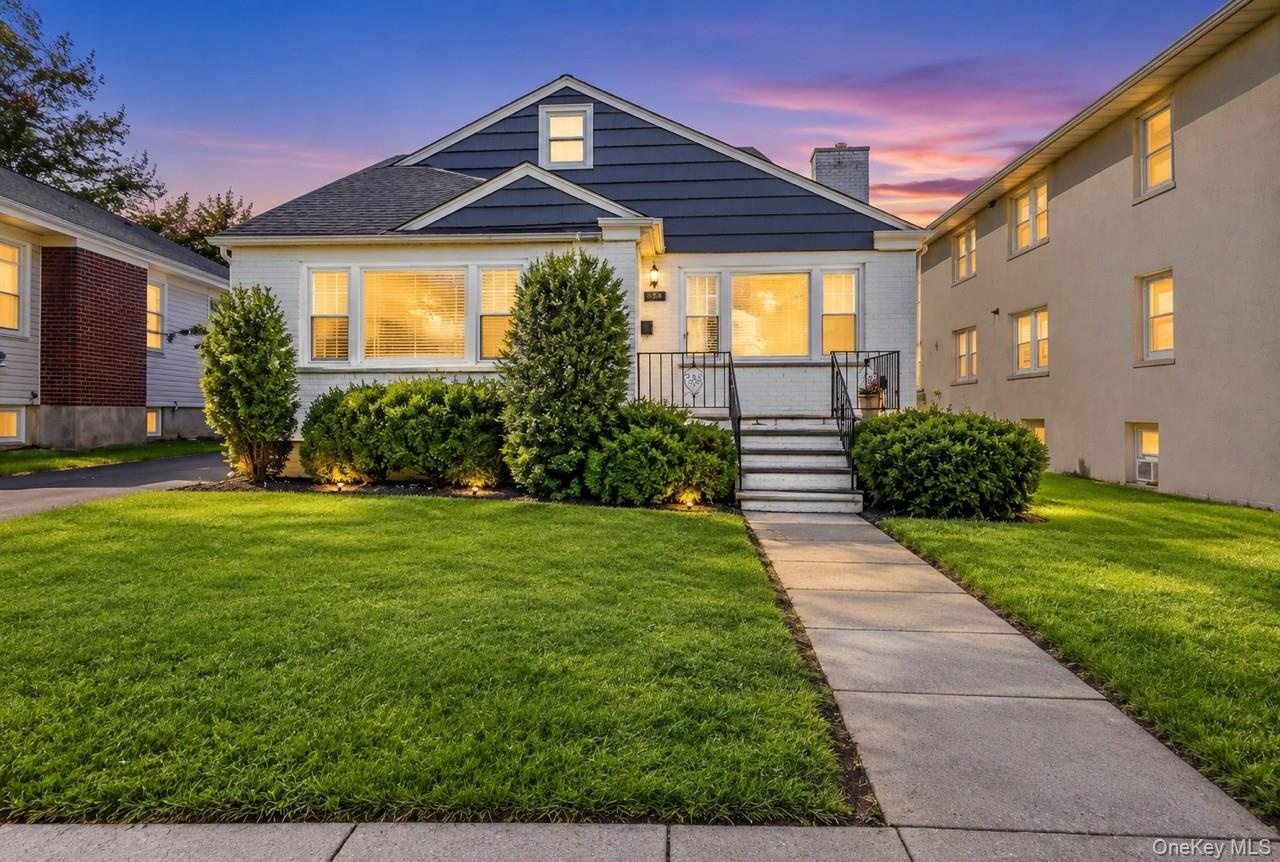 Front exterior featuring a gabled roof, white siding, and dark blue shingle accents