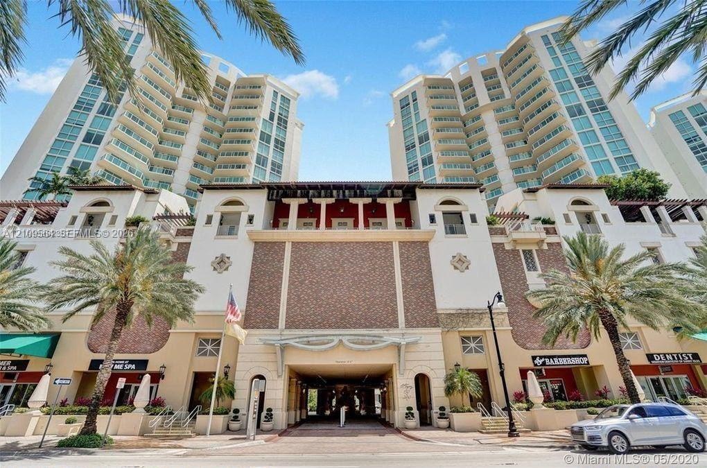 Multi-story high-rise architecture featuring glass balconies, brick-accented exterior masonry, arched entryways, and integrated ground-floor commercia