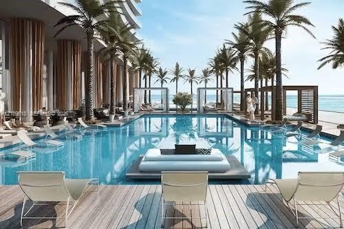 Resort-style swimming pool featuring a central floating lounge island, integrated pool-level sun decks, wood-finish decking, and perimeter cabanas