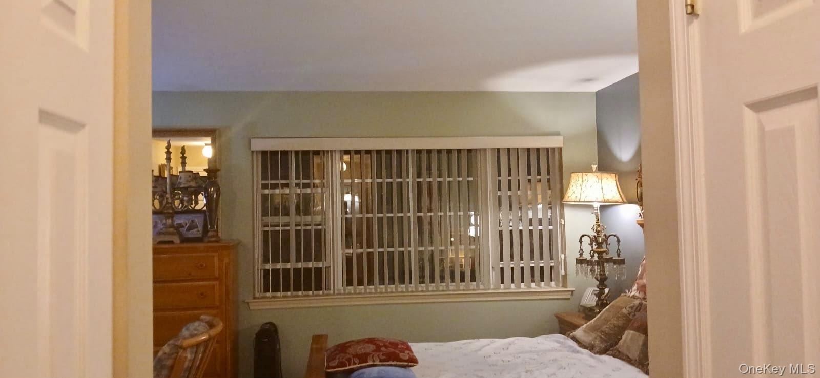 Room featuring multi-pane window with vertical blinds and dual-panel interior doorway