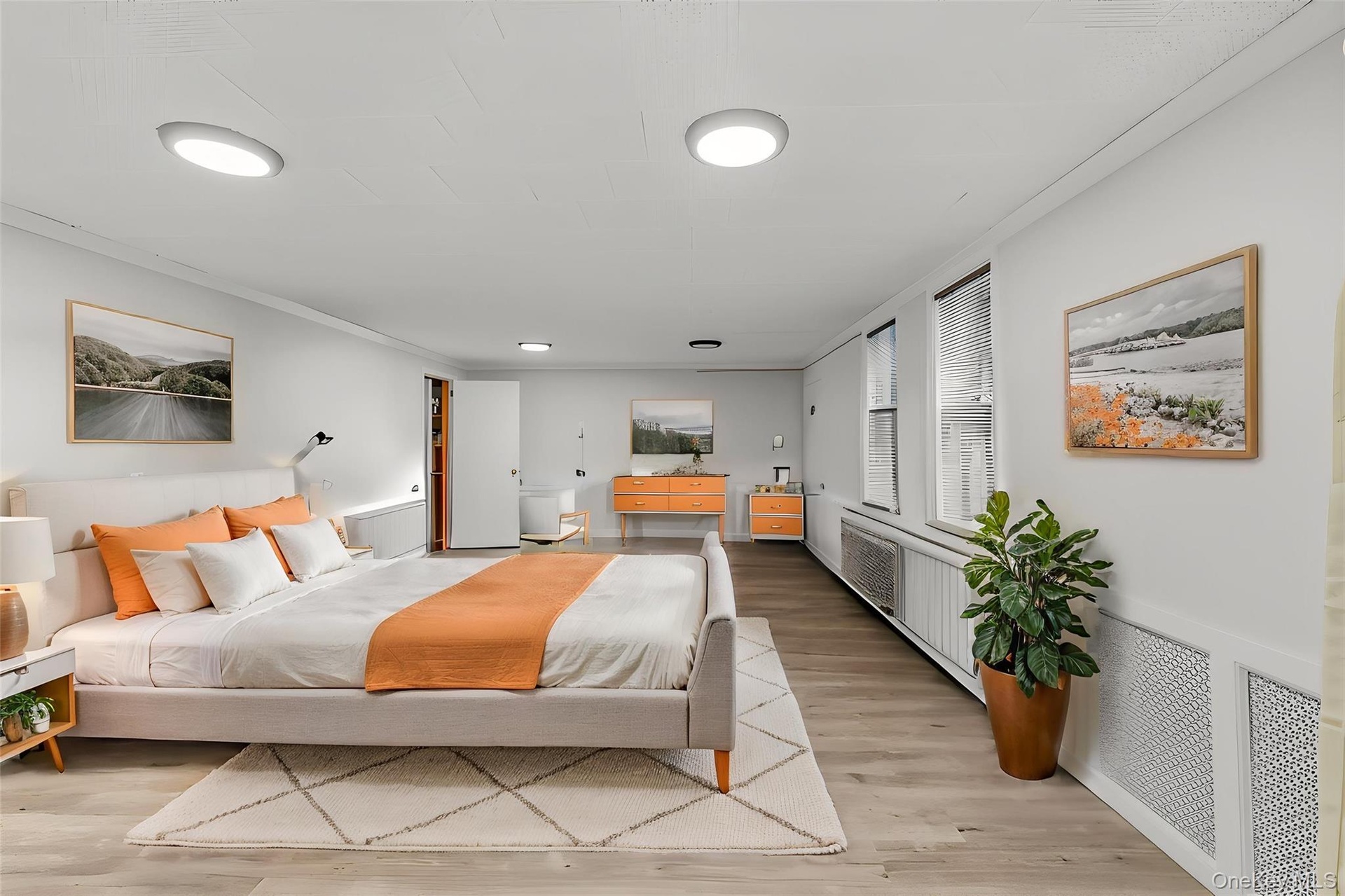 Recessed ceiling lighting, wood-finish flooring, multiple windows with blinds, and white wall finishes