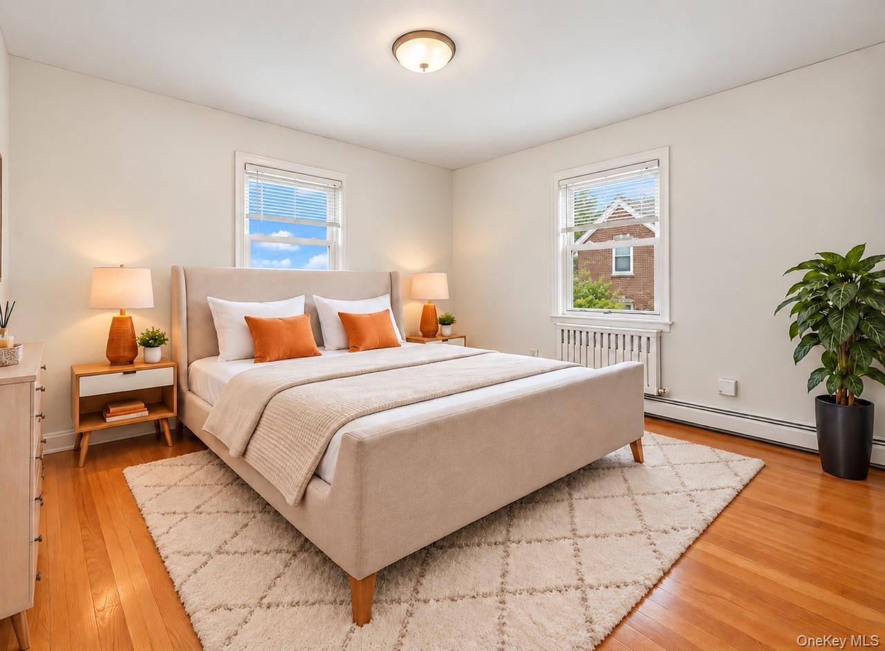 Hardwood flooring, two windows with blinds, and white walls