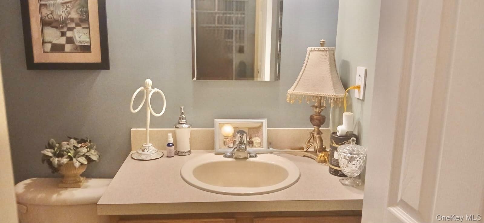 Wall-mounted mirror, vanity featuring a solid-surface countertop with an integrated basin, and single-handle chrome faucet