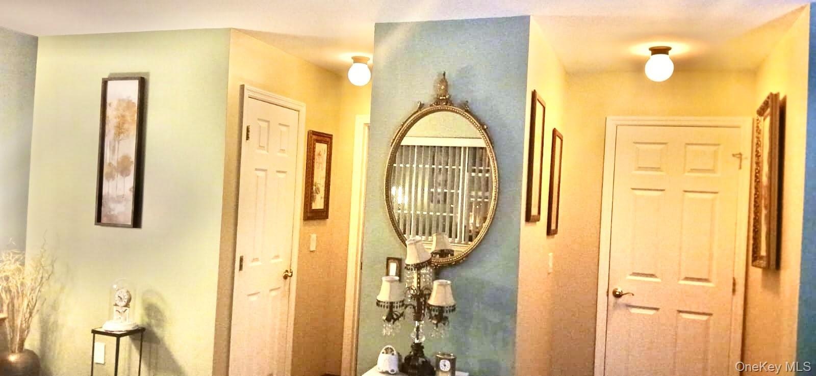 Interior hall area featuring two six-panel solid core doors and dual globe-style flush mount light fixtures