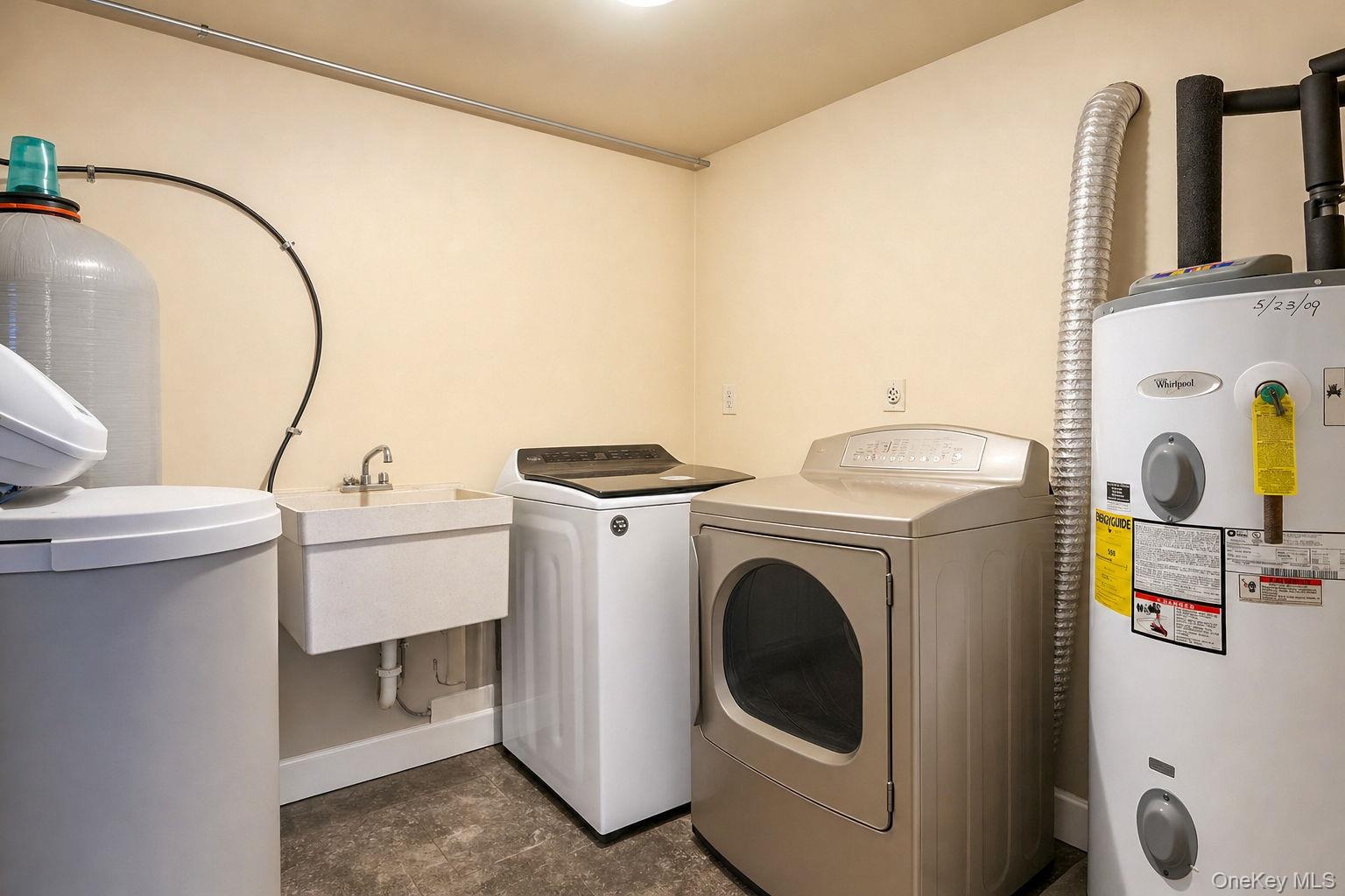 Laundry/utility room with washer and dryer, utility sink, hot water heater, and water purification system
