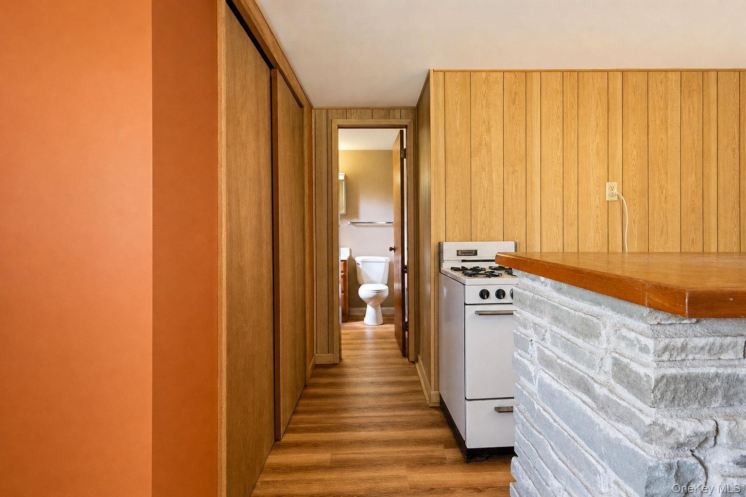 Family room hallway with dual sliding door storage closet and entrance to the half bath
