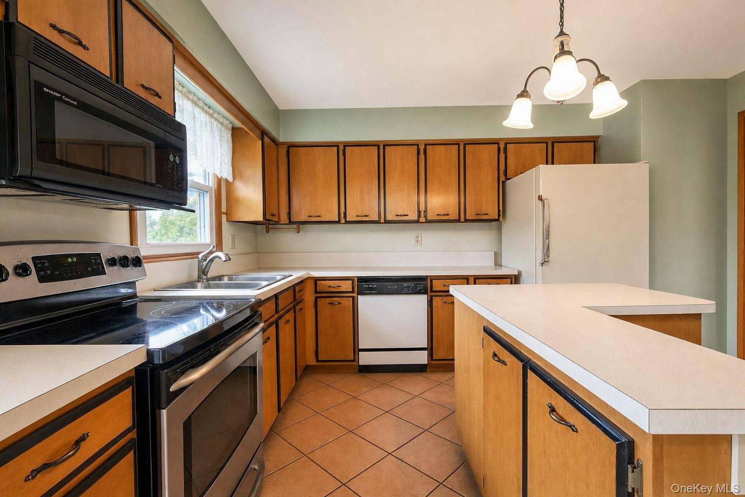 Kitchen featuring wood cabinetry, solid-surface countertops, tile flooring