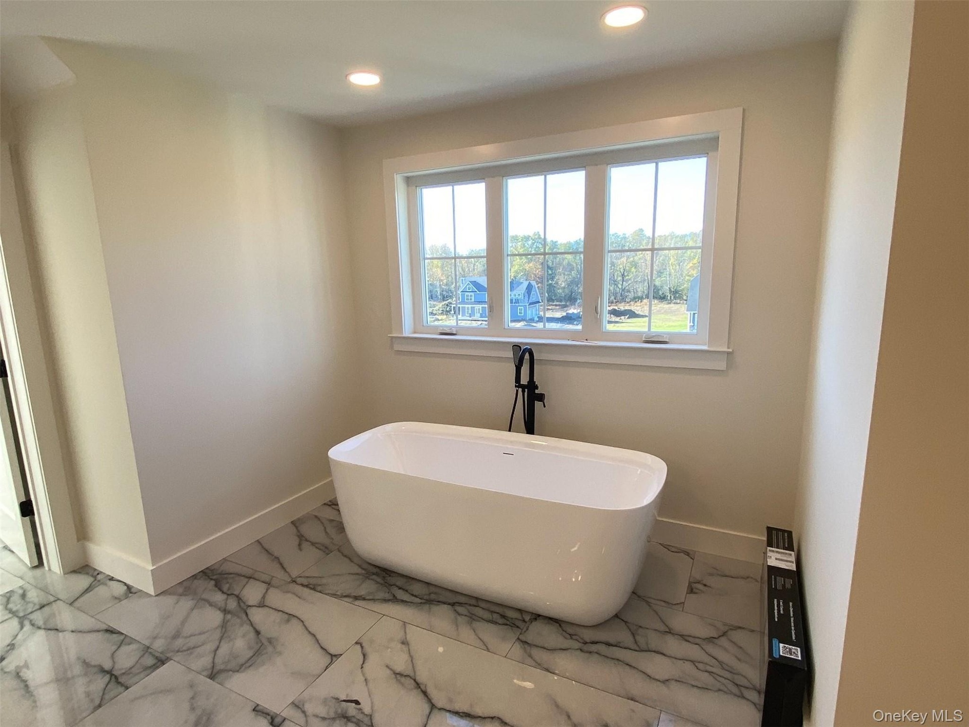 Enjoy the beauty and convenience of the newly installed free standing soaking tub beneath a window to create an inviting space.