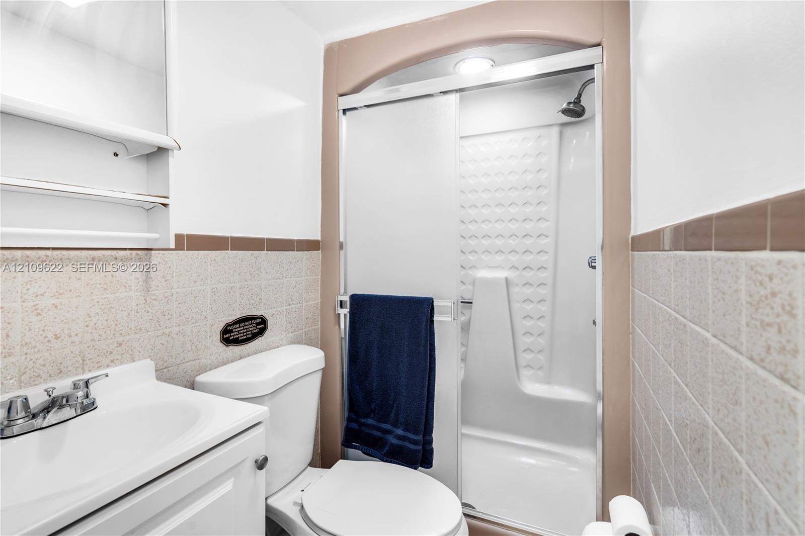 Bathroom featuring a walk-in shower with a glass sliding door, molded shower surround, recessed ceiling lighting, and a pedestal sink