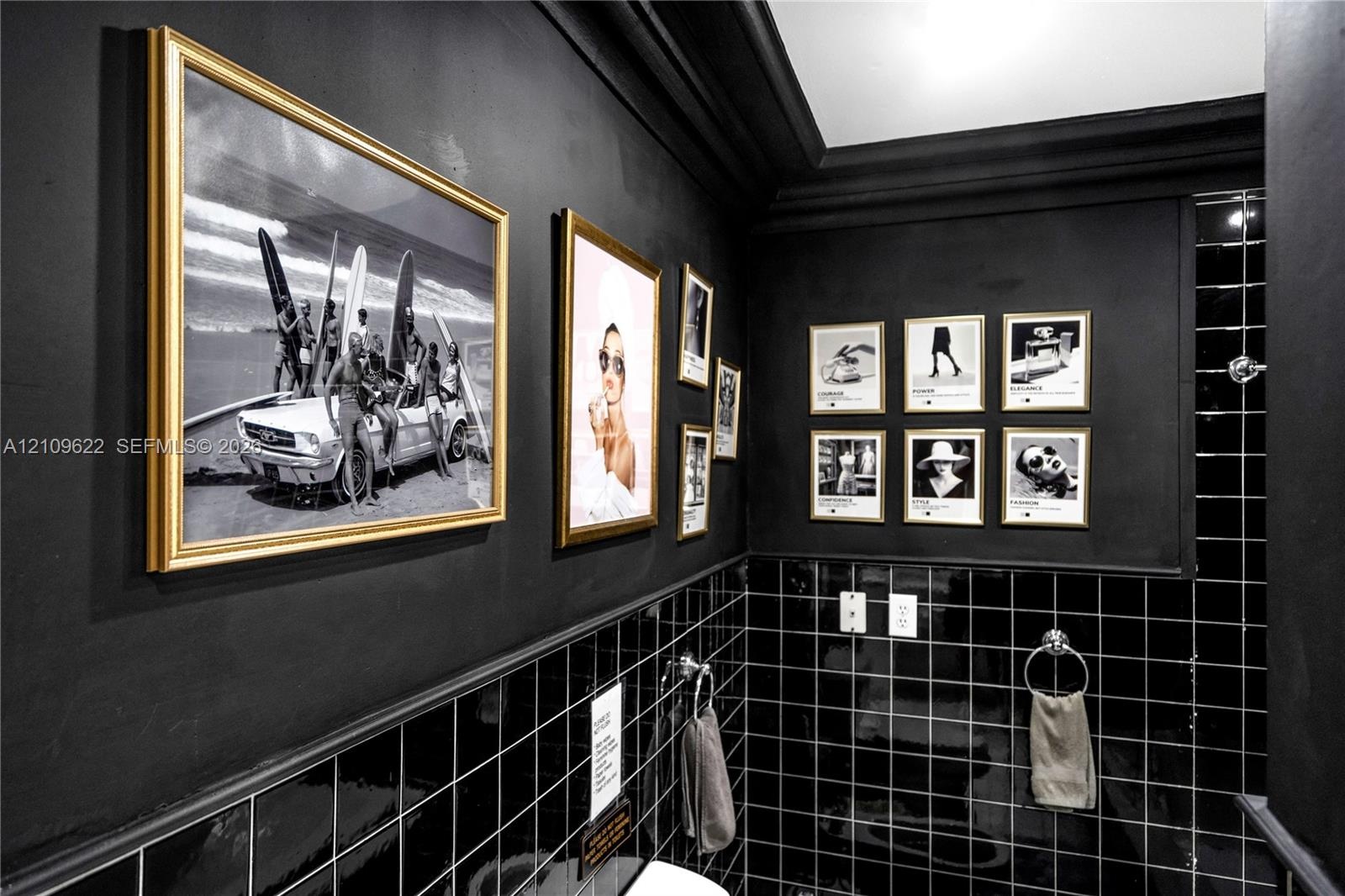 Interior wall featuring matte black wall paint, black square-tiled wainscoting, and crown molding