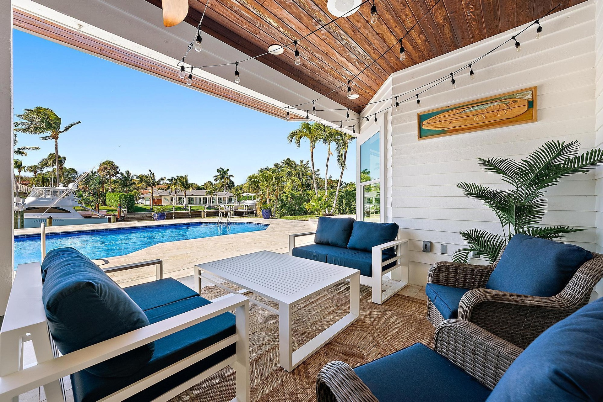 Covered patio featuring a wood-plank ceiling, horizontal siding, recessed lighting, and direct access to an inground pool and water frontage