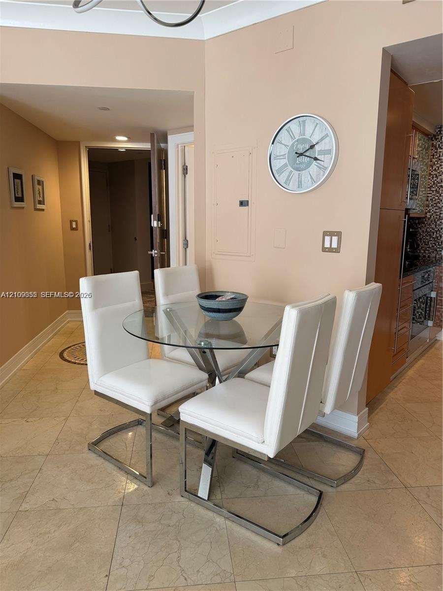 Neutral-toned interior featuring large-format tile flooring, crown molding, and recessed lighting