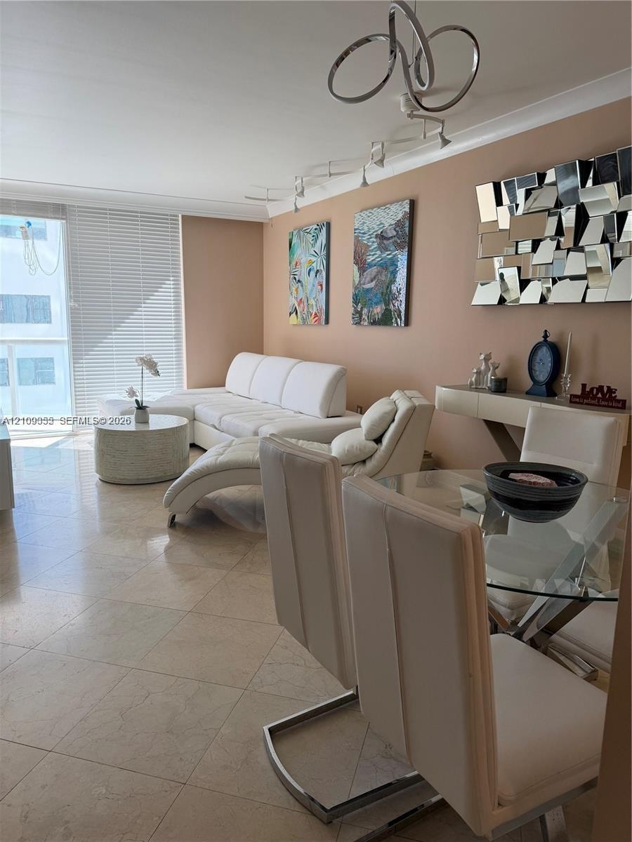 Polished stone flooring, floor-to-ceiling sliding glass doors, horizontal slat blinds, and decorative multi-arm ceiling lighting