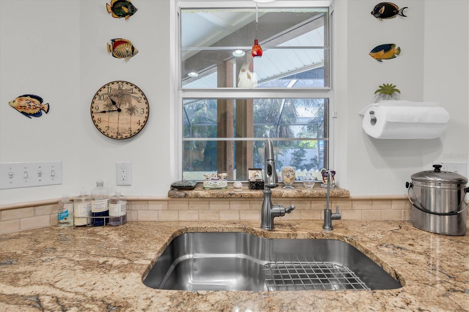 Kitchen sink overlooks lanai and pool and spa area. New garbage disposal in 5/25.