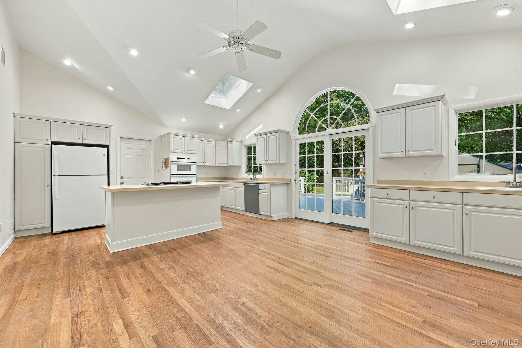 Spectacular kitchen with soaring ceilings, Sliders to deck with Palladium window.