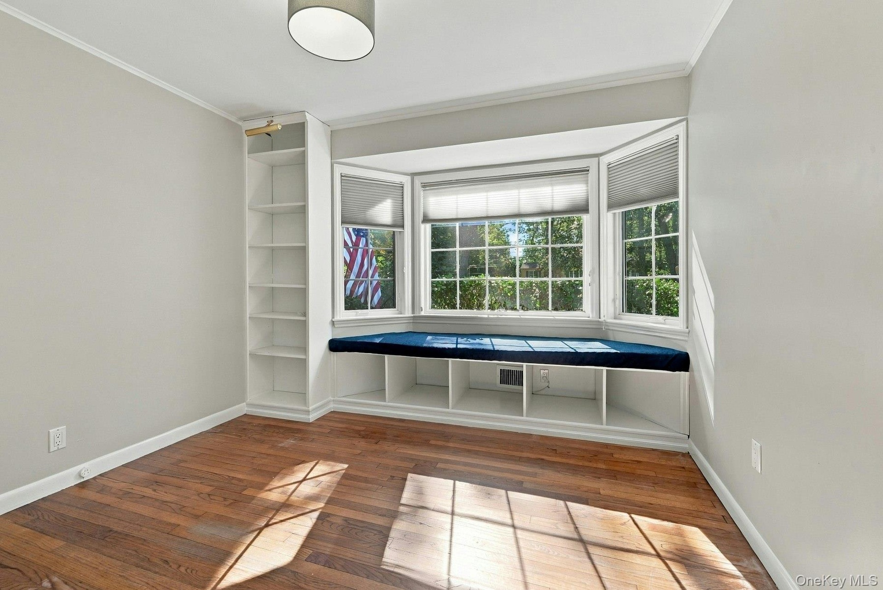 Front bedroom with bay window with seating and built-in bookshelves.