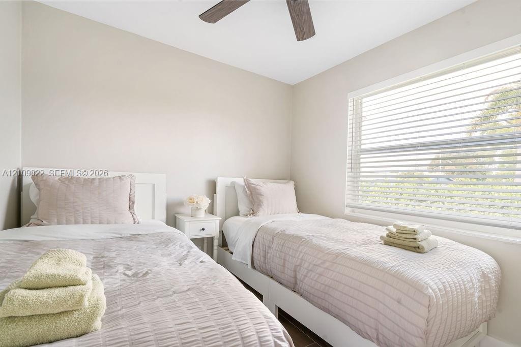 Neutral interior with horizontal window blinds and a ceiling fan