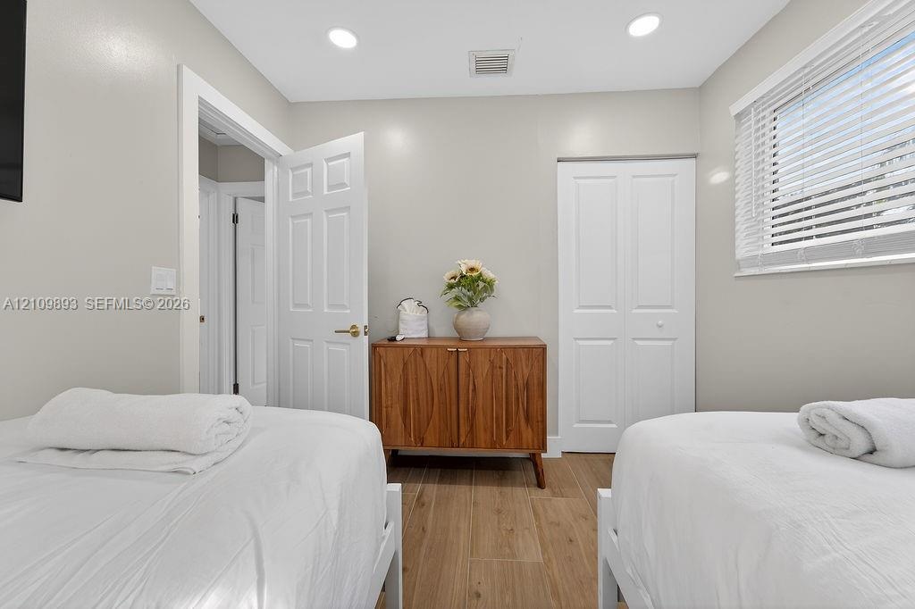 Neutral-toned room featuring wood-finish flooring, recessed lighting, and a closet with double-panel doors
