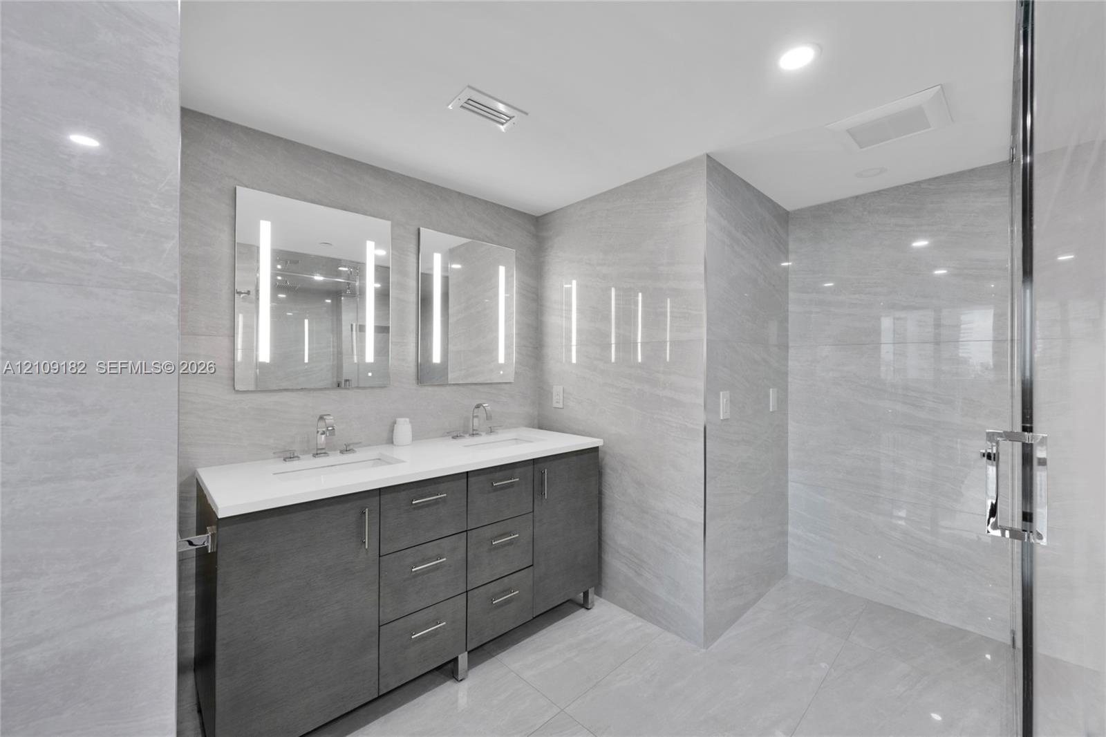 Floor-to-ceiling sliding glass doors, large private balcony with metal railing, polished stone-finish flooring, and expansive window lines